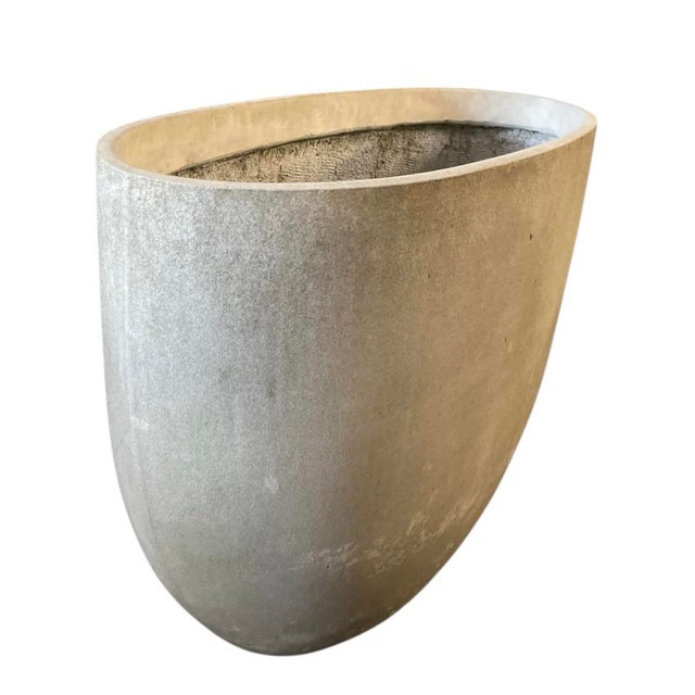 A monumental oval-form planter. Standing at an impressive 31 inches tall, this piece combines the substantial, industrial...
