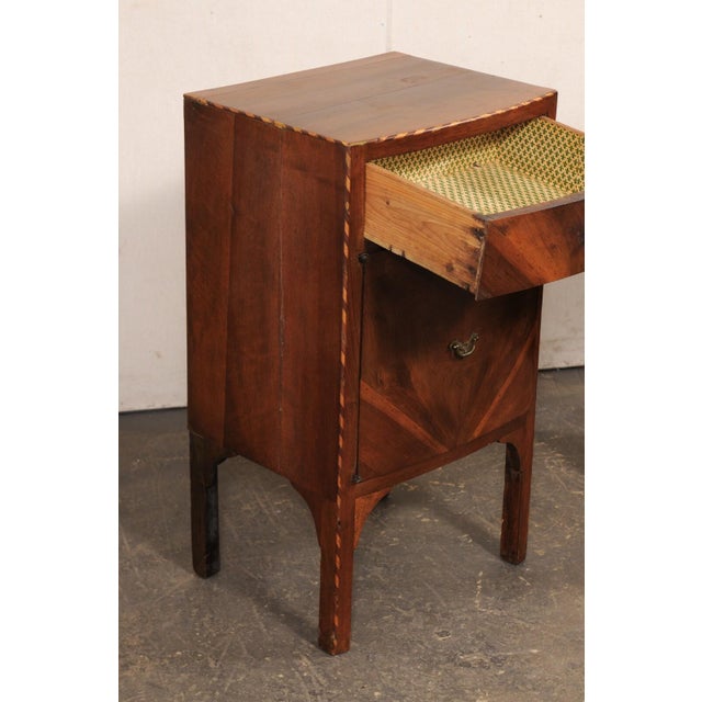 An Italian pair of wooden side chests with veneers and decorative inlay banding, from the 19th century. These antique...