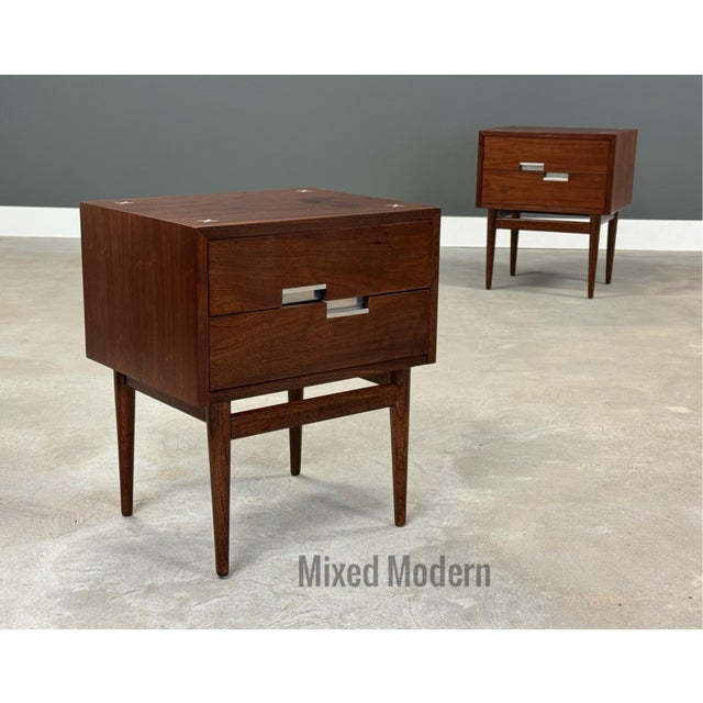 A pair of mid century modern walnut two drawer nightstands with aluminum x inlay and off set aluminum pulls designed by...