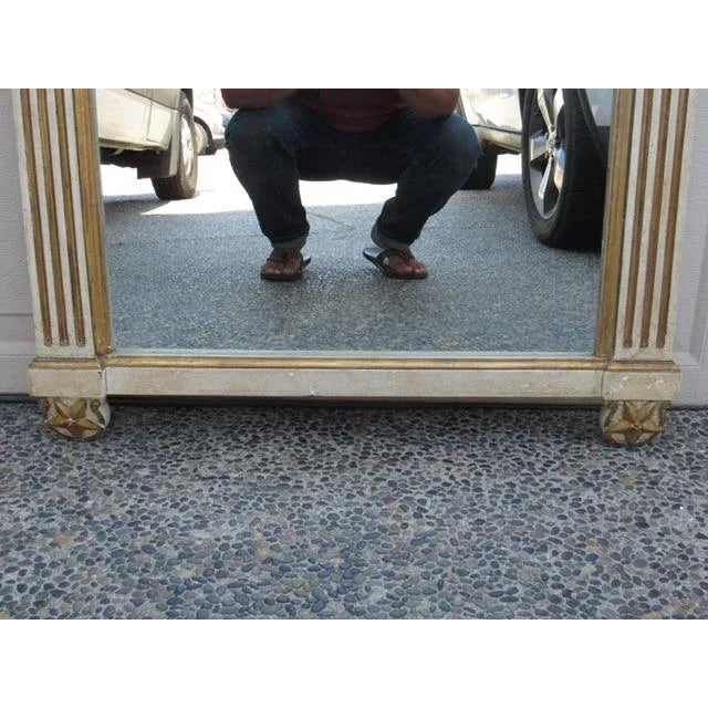 Painted and gilt neoclassical style Italian mirror, c.1940’s Painted and gilded, this mirror has reeded column sides and a...