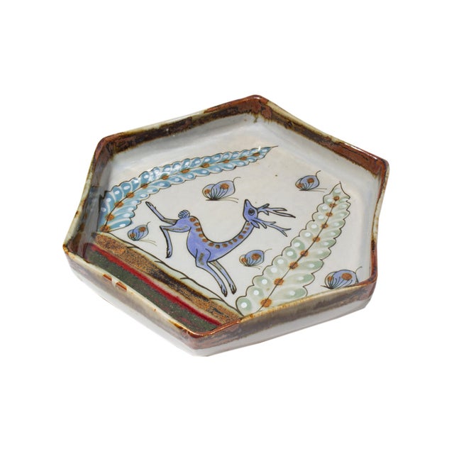A Mexican Tonala pottery hexagonal plate featuring a deer by American artist Ken Edwards. This plate features a blue deer...