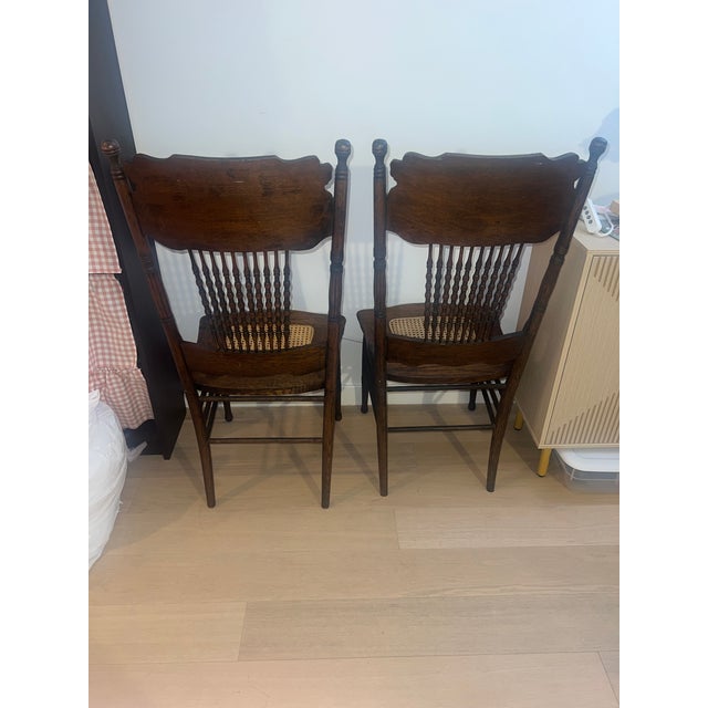 An exceptionally striking pair of antique Victorian Eastlake-style dining chairs featuring intricate carved lion motifs,...
