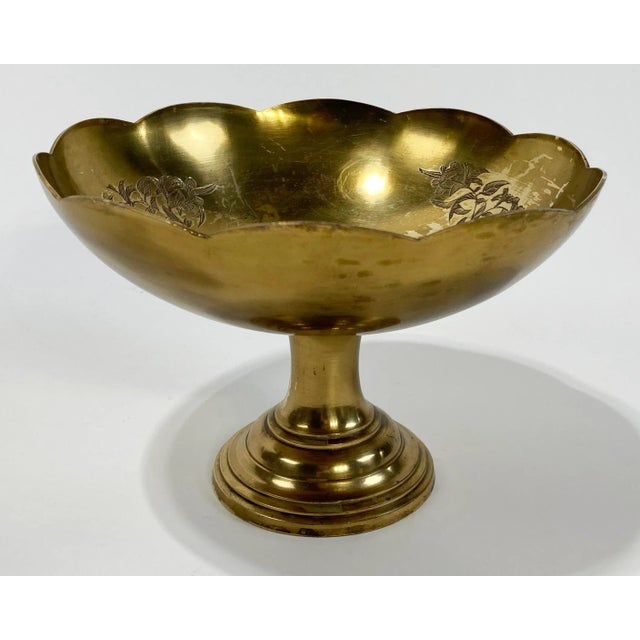 Vintage heavy brass engraved compote bowl on a pedestal stand. Engraving inside bowl features flower bouquets. Patina.