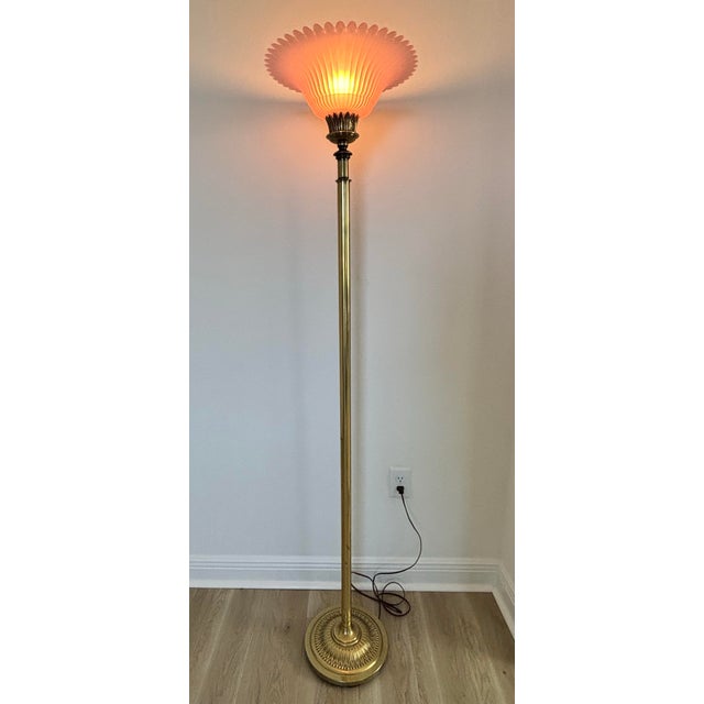 Vintage Hollywood Regency/Art Deco brass torche/floor lamp. The shade is pink glass with scalloped edges. It is a tap to...