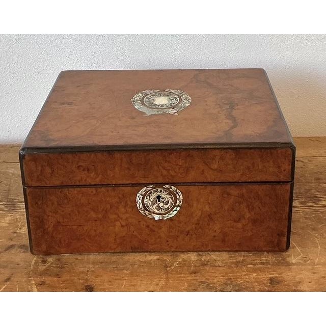 This exquisite Victorian-era traveling writing box is a masterclass in late 19th-century artisanal luxury. The exterior is...