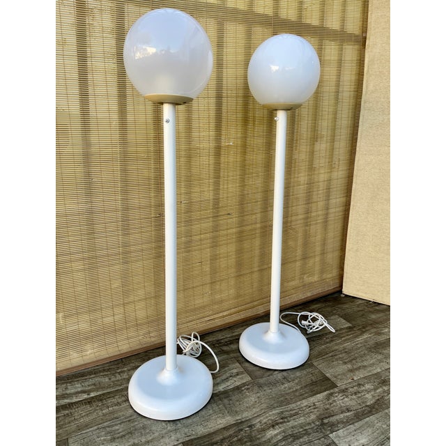 A pair of Vintage Postmodern White Lollipop Floor Lamps. Circa 1980s Features a white plastic globe-shaped shade with a...