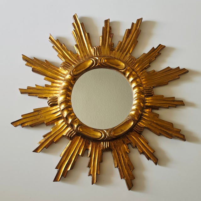 Beautiful gilded sunburst mirror from the 1960s This striking mirror is designed in the shape of a stylized sun. The round...