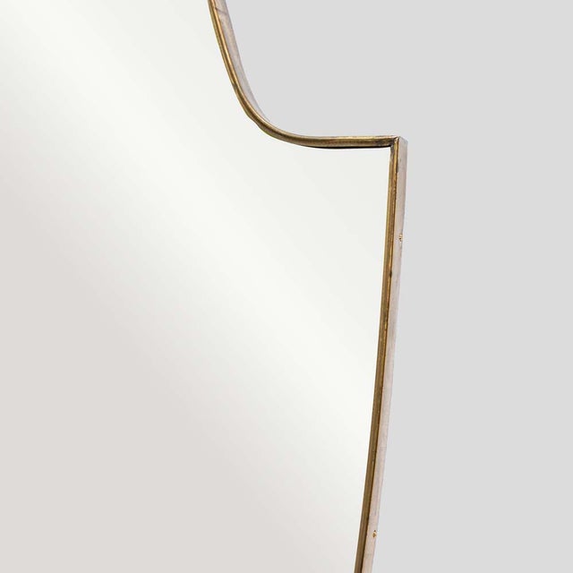 Large vintage Italian design shield shaped brass mirrorA brass mirror featuring an arched top and oval shaped sides,...