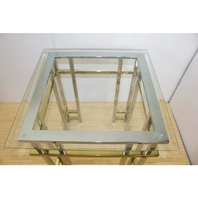Large end tables, each with bevelled glass top atop a chromed steel and brass frame. Superior quality, in the style of...