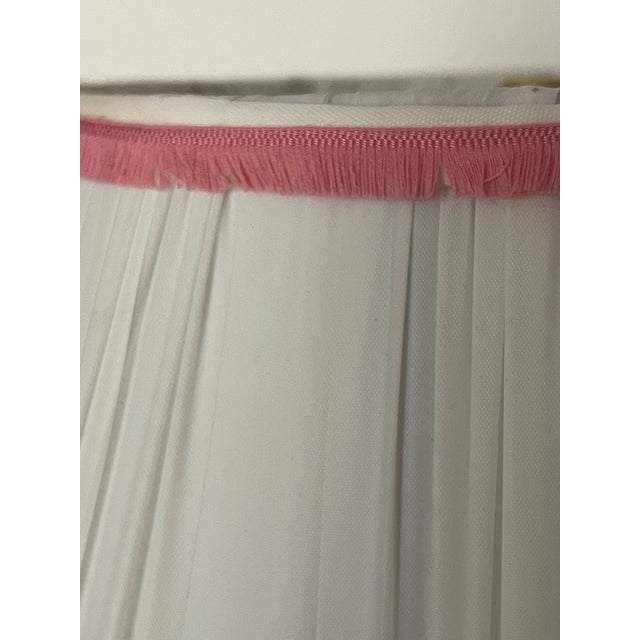 Handpainted ceramic table lamp with white pleated shade trimmed in pink fridges.