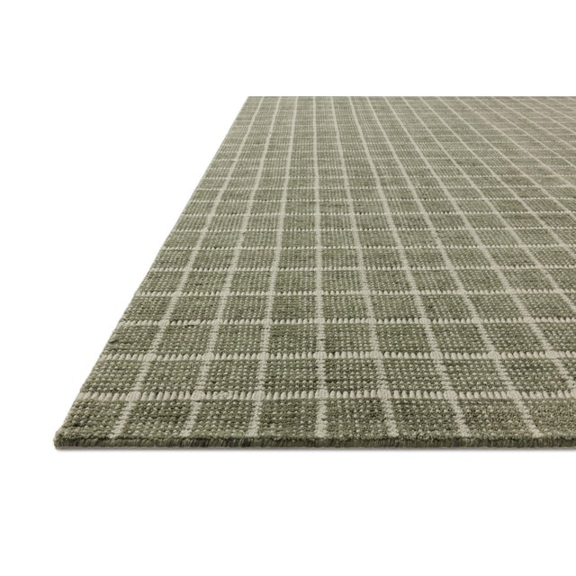 The Cedar Collection by Amber Lewis x Loloi is a hand-loomed area rug with a clean gridded design in contrasting ivory....