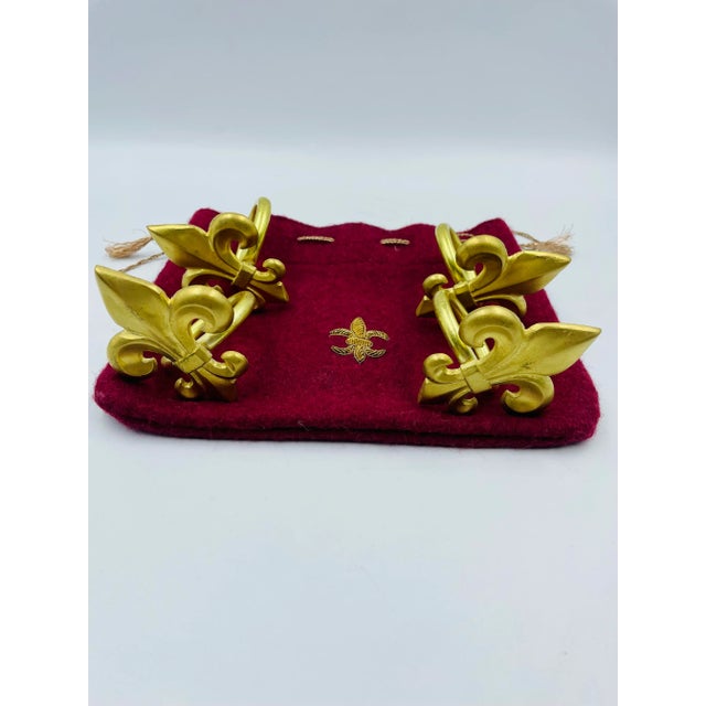 This stunning set of golden "fleur de lis" napkin rings comes in the original corresponding wool pouch that features a...