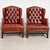 Pair of 20th century Danish Chesterfield wingback club chairs upholstered in vintage tufted leather with a rich reddish-...
