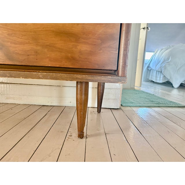 A classic mid-century modern six-drawer dresser attributed to Harmon House, featuring the clean lines, tapered legs, and...