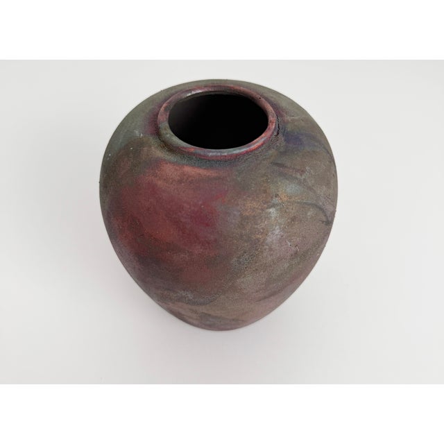 Small clay Raku vase measuring 5.5" high. Produced in the late 20th century and featuring subtle iridescent shades of...