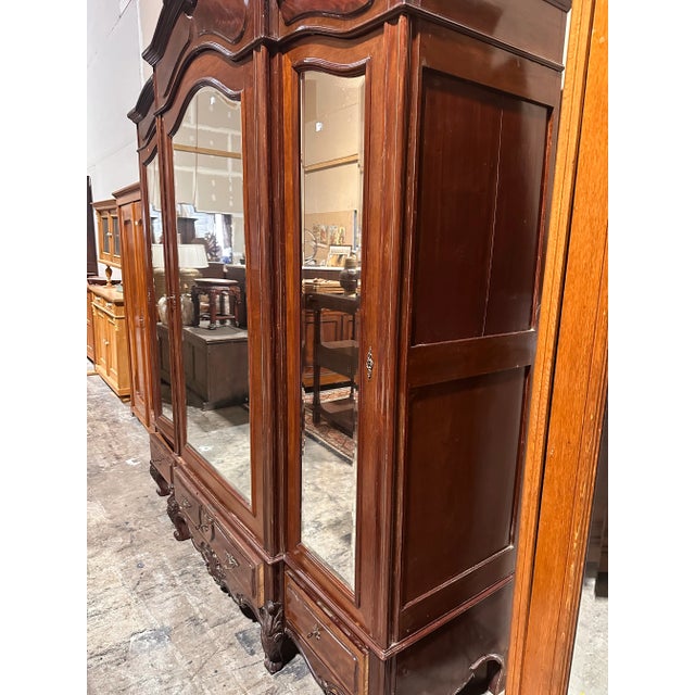 An exceptional example of French craftsmanship circa late 19th, this grand three-door armoire is executed in richly...