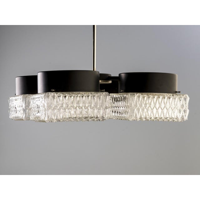 This four-light chandelier was produced by Napako, Czechoslovakia, in the late 1970s to early 1980s. It combines pressed...