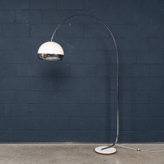 A striking italian arc floor lamp dating to the 1970s, showcasing the elegant, space-age aesthetic of the period. The...