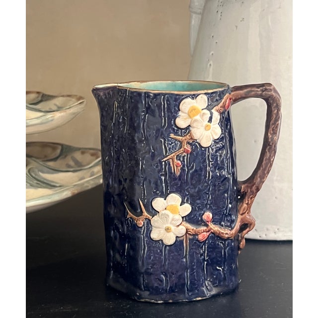 English majolica pitcher made by Joseph Holdcroft in the 1890's. The cobalt blue pitcher has a bark form, it is covered...