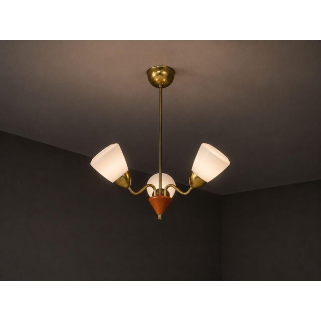 Swedish Mid-Century Modern, Pendant Light, Brass, Glass, Teak, Sweden, 1950s A three (3) light brass, glass, and teak...