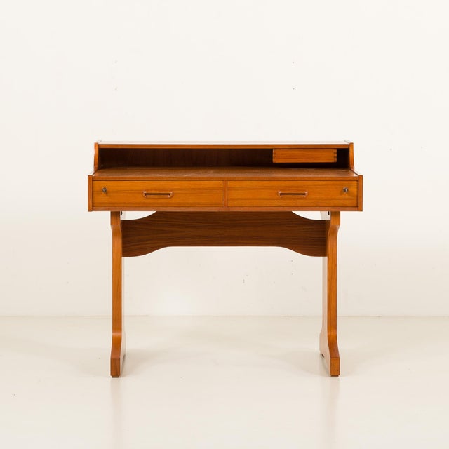 The stylish teak italian mid-century desk from the 1960s showcases the refined aesthetics typical of that era. It's a part...