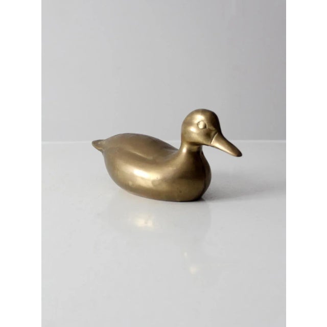 This is a mid-century brass duck figurine. The heavy-weight brass duck has great lines, detail, and patina.