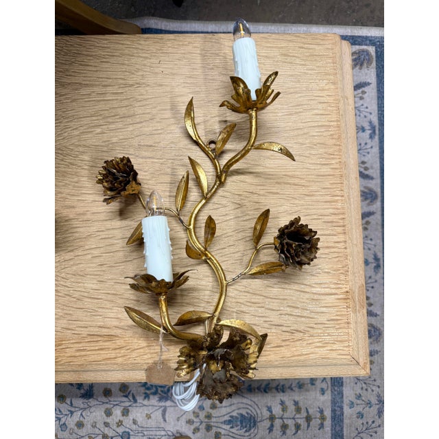 A beautifully matched set of three antique French tole wall sconces, featuring hand-formed gilt metal florals and...