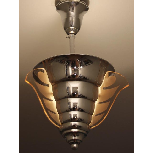 This round Art Deco chandelier by Petitot is made of chrome-plated brass and features three vertical, rose-colored,...