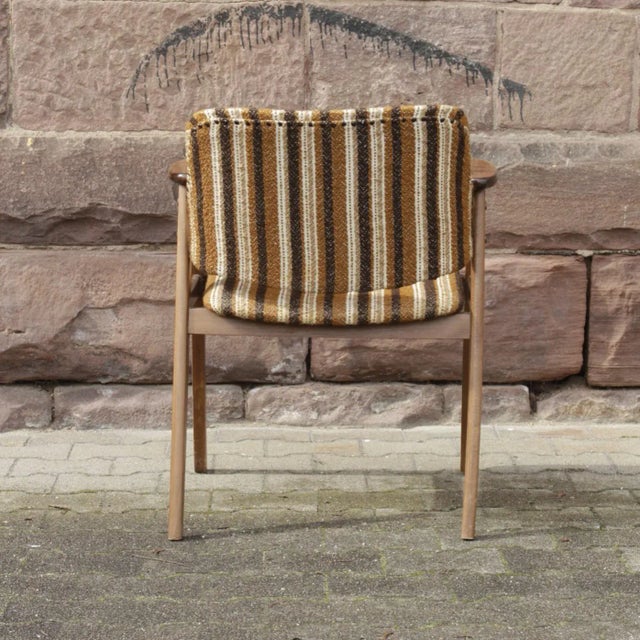 Vintage armchair made with a wooden structure in the Scandinavian style. Original upholstered in striped fabric.