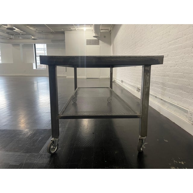 Vintage style metal industrial table on wheels, circa 2000 Industrial table made of steel on wheels.