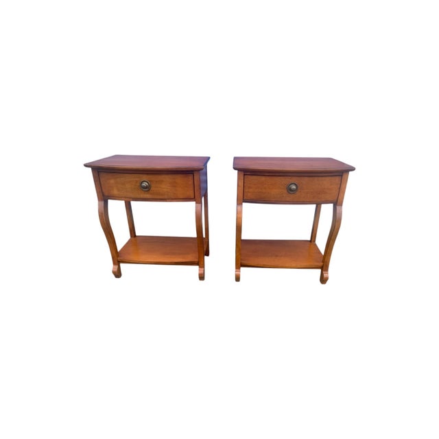 A pair of early Tommy Bahama side tables or nightstands by Lexington. Features classic styling with a curved front,...