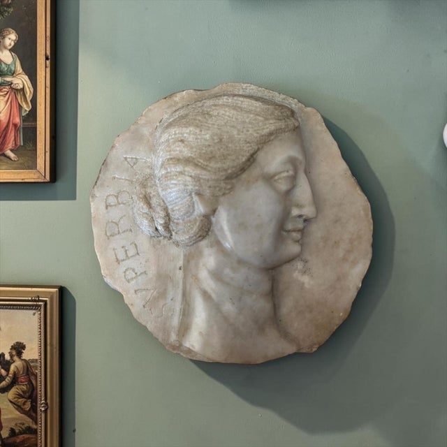 A beautifully executed hand-carved marble relief plaque depicting an idealized female profile, likely representing...