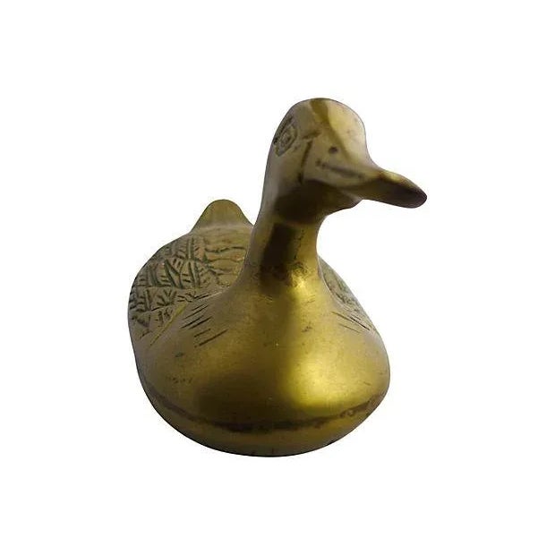 Swimming duck in solid brass. Maker's mark reads: "Williamsburg Pottery."