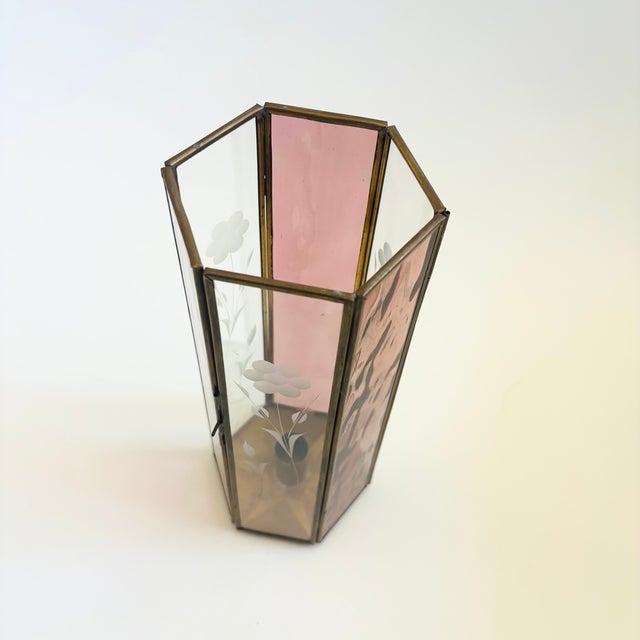 A tall vintage brass and glass candle holder. Hexagonal in shape with thin panes of pink and clear glass are held together...