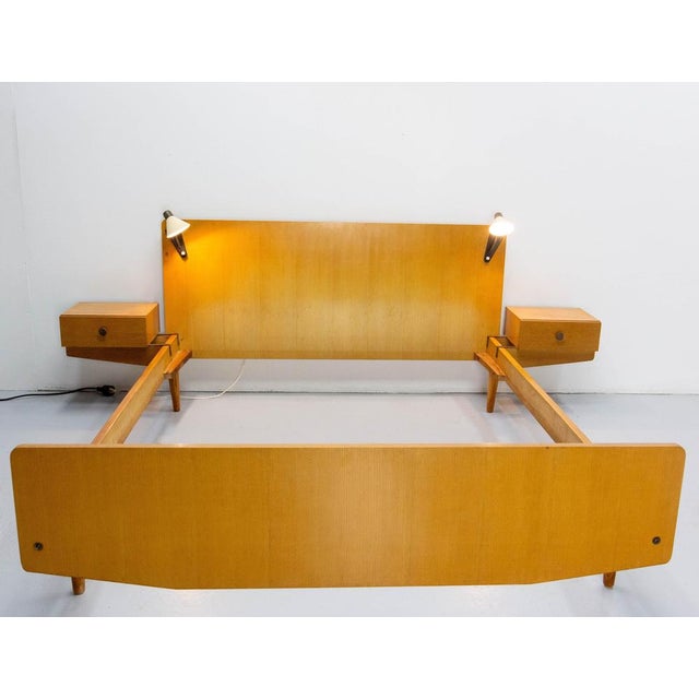 French bed made in the 1950's with oak, metal sheet and brass. The nightstand tables and the bed lamps are included. The...