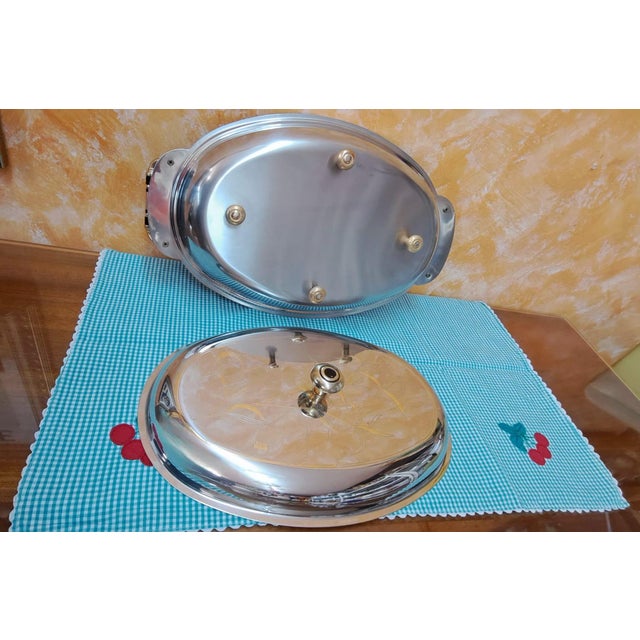Stainless steel (18/10) lidded serving tray with 24-karat gold details by the Italian firm Giorinox. Oval shape with...