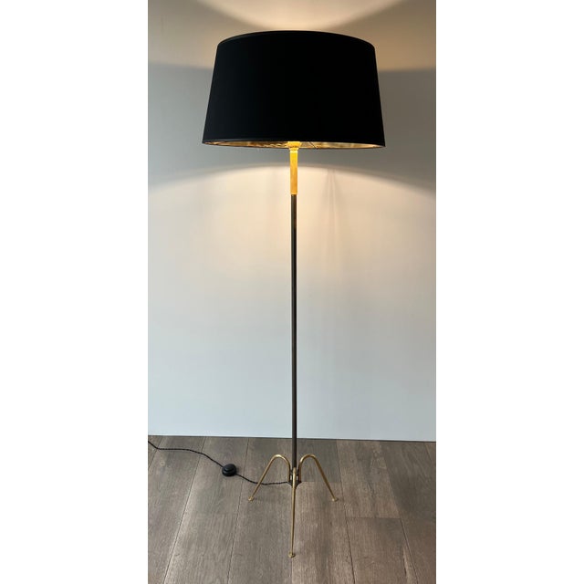This beautiful floor lamp with an interesting design is made of reinforced metal and brass. It is a French work. Circa 1960