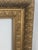 A beautifully detailed early 20th century gilt picture frame featuring a substantial, multi-layered architectural profile...