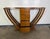 This striking Art Deco console features a bold, symmetrical silhouette centered around a vertical stack of four drawers...