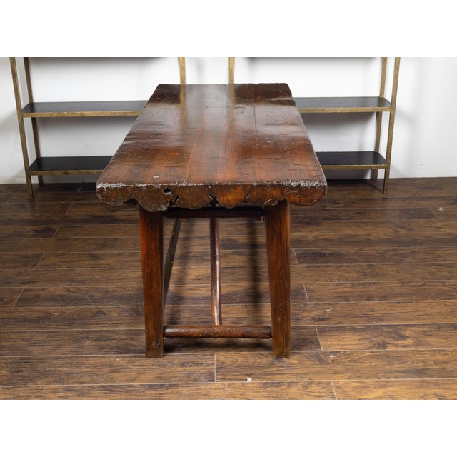 An American rustic pine log table from the early 20th century, with straight legs and side stretchers. Made in the USA...