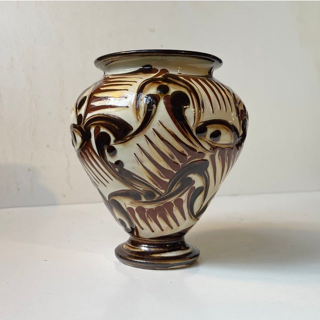 A stylish footed earthenware vase decorated with brown and black glazed over a cream-colored background. Unusual abstract...