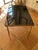 Neoclassical style coffee table from the 1930s/40s. The table legs are made of solid brass, and the frame is topped with...