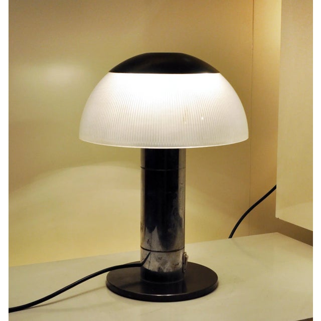 This table lamp in glass and metal was produced in Italy in the 1960s. I have official proof of authenticity such as...