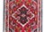 An early 20th century Persian Hamadan rug with a central floral medallion amidst a field of scrolling vines and flowers,...