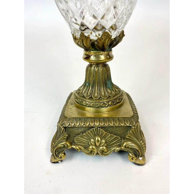 A glass and brass vessel that is bright and sparkly. This item has a mold line running through the glass