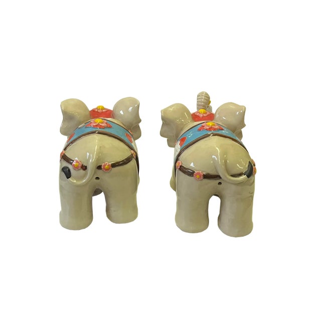 This is a pair of delicate handmade elephant figures with a clay beige color and charm accent on the body. The elephant...