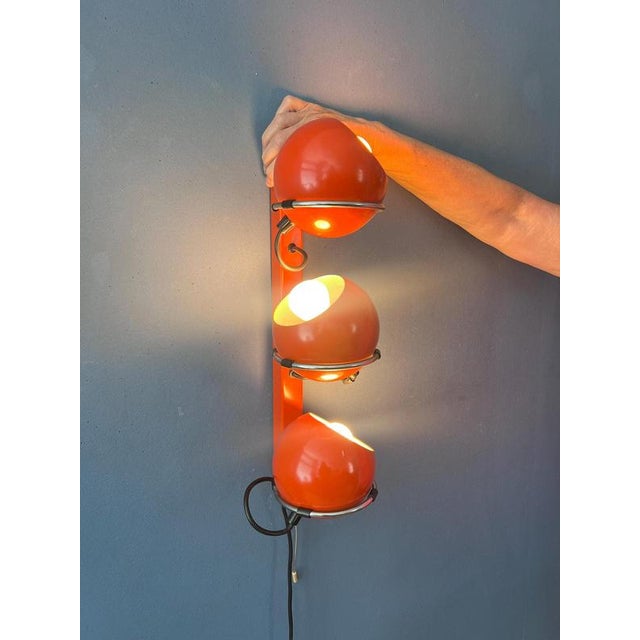 An iconic vintage space age wall lamp by dutch lighting manufacturer gepo, featuring three striking metal eyeball shades...