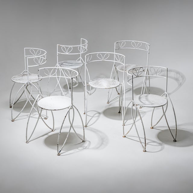 Set of six vintage lawn or garden chairs featuring an intricate, stylized tulip design with rounded backrests. Crafted...