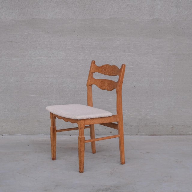 An upholstered set of dining chairs in a white boucle style fabric. Denmark, c1960s. Oak framed, heavily attributed to...