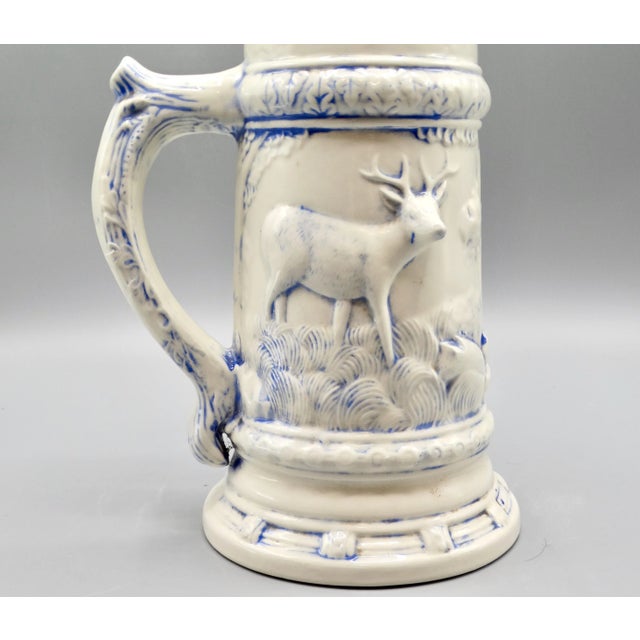 Large statement size lidded drinking stein depicting a hunter, dog, and a stag with lovely detail. It is 13 inches in...